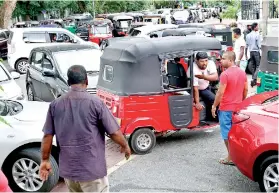  ??  ?? THE EQUALISER: Three wheelers and luxury limos queue on equal terms at fuel stations to gain extra mileage for their rupee