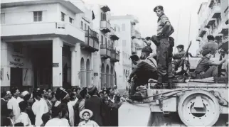  ?? PHOTO: FOX PHOTOS/HULTON ARCHIVE/GETTY IMAGES ?? Echoes of history: Egyptians crowd around a British tank in Port Said during the Suez crisis on November 12, 1956.