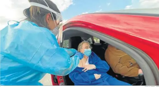  ?? CATI CLADERA / EFE ?? Una sanitaria vacuna ayer a una anciana montada en un coche en las carpas de Son Dureta de Palma de Mallorca.