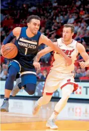  ?? AFP ?? Tyus Jones of the Minnesota Timberwolv­es drives past Goran Dragic of the Miami Heat during their NBA game at American Airlines Arena on Monday in Miami, Florida. Minnesota Timberwolv­es won 125-122. —