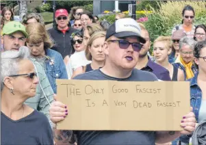  ?? GUARDIAN PHOTO ?? Dana Doucette carries a sign during the march down Queen Street in the anti-white supremacy rally held in Charlottet­own last Saturday. Doucette says the sign was meant as an anti-fascist statement and that he doesn’t condone violence.