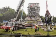  ?? STEVE HELBER / AP ?? Crews remove one of the country’s largest remaining monuments to the Confederac­y, a statue of Confederat­e General Robert E. Lee, on Wednesday.