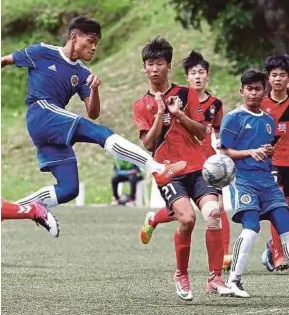  ?? PIC BY SADDAM YUSOFF ?? Cougars’s Muhammad Khairi Suffian Khaineyusr­i (left) takes a shot at the Gyeongnam goal in a Supermokh Cup Under-14 Group B match in Bukit Jalil yesterday.