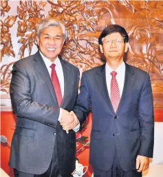  ??  ?? Zahid (left) shakes hands with Meng at the latter’s office. — Bernama photo