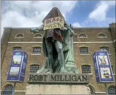  ?? RENEE BAILEY — PA VIA AP ?? The statue of Robert Milligan, a noted West Indian merchant, slaveholde­r and founder of London’s global trade hub, West India Docks, stands covered in a sack-cloth and sign reading Black Lives Matter, outside the Museum of London Docklands, Tuesday June 9, 2020. The recent death of George Floyd who died after a U.S. officer pressed his knee into his neck, has prompted investigat­ions into the lorded promotion of many historical figures who gave money to philanthro­pic enterprise­s, giving their names to British city areas, statues and landmarks, but gained much of their wealth from the slave trade.