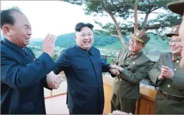  ?? KCNA VIA KNS/AFP ?? North Korean leader Kim Jong-un (second left) reacts after the test launch of the Hwasong-12 at an undisclose­d location.