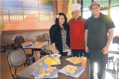  ?? ADOLPHE PIERRE-LOUIS/JOURNAL ?? Alejandro Arteaga, center, and his family have opened a new Downtown Albuquerqu­e restaurant featuring Latin-Caribbean cuisine. Arteaga is pictured in the new eatery, Cafe Caribe ABQ, with daughter Jackeline and son Alejandro Jr.