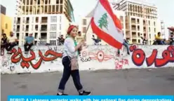  ??  ?? BEIRUT: A Lebanese protestor walks with her national flag during demonstrat­ions yesterday. —AFP