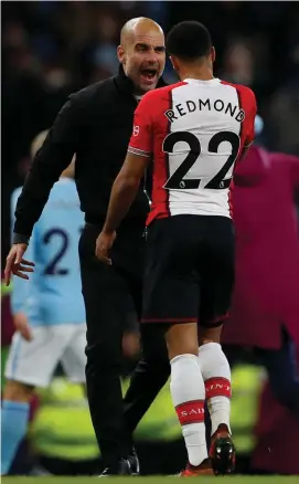  ??  ?? Pep Guardiola speaks with Nathan Redmond after Manchester City’s late victory against Southampto­n on Wednesday