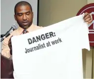  ?? PHOTO BY IAN ALLEN ?? In this May 2, 2014, photograph, journalist Rohan Powell displays a shirt proclaimin­g the role of the media at a World Press Freedom Day Forum at the Knutsford Court Hotel in New Kingston.