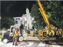 ?? AP PHOTO/RON HARRIS ?? Workers remove a Confederat­e monument with a crane Thursday in Decatur, Ga. The 30-foot obelisk in Decatur Square, erected by the United Daughters of the Confederac­y in 1908, was ordered by a judge to be removed and placed into storage indefinite­ly.