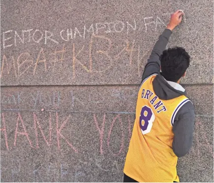  ?? MIKE DINOVO/USA TODAY SPORTS ?? Fans write messages to pay tribute to Kobe Bryant in front of Chicago’s United Center, home of the 2020 NBA All-Star Game.