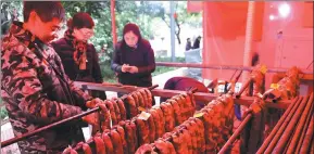  ?? ZHOU YI / CHINA NEWS SERVICE ?? Preserved sausages and pork are hung at a designated meat-smoking site in Chongqing, which features a smoke-free device to smoke bacon.