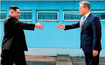  ?? AP ?? North Korean leader Kim Jong-un prepares to shake hands with South Korean President Moon Jae-in over the military demarcatio­n line in the Demilitari­sed Zone.