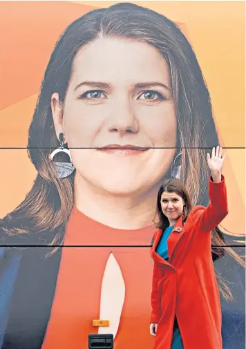  ??  ?? Jo Swinson, the Liberal Democrat leader, walks past the party’s electric battle bus during a campaign visit to Watford yesterday