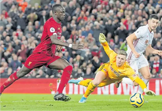  ?? AP ?? Una de las fórmulas. Define el senegalés Sadio Mané, tras recibir el pase del egipcio Mohamed Salah. Fue el 2-0 ante Sheffield United.