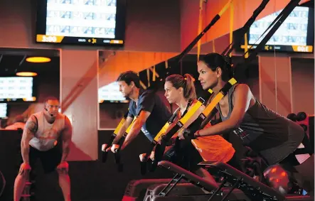  ??  ?? Orangetheo­ry Fitness workouts are a mix of cardio and strength training, using a combinatio­n of free weights, treadmills, rowing machines, and TRX suspension training throughout different intervals of the workout.