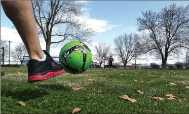  ?? NWA Democrat-Gazette/J.T. WAMPLER ?? Jesus Pascual of Springdale kicks a ball to his son Pedro Pascual, 9, on Monday at Luther George Park in Springdale. The park, near downtown, features pavilions, exercise equipment, playground­s, a skate park and open grass areas.