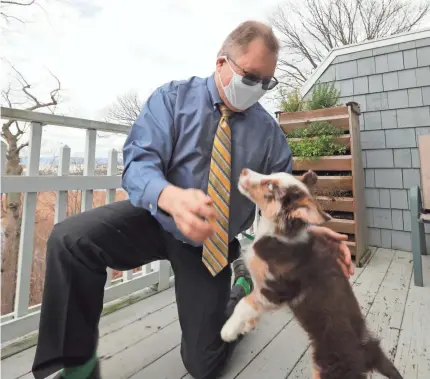  ?? PETER CARR/USA TODAY NETWORK ?? Dr. Mark Kittleson plays with his dog, Toby. Kittleson said it’s important to remain active. “We’re not meant to be cooped up inside,” he said.