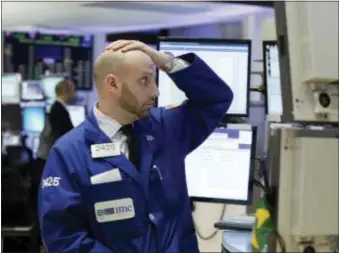  ?? RICHARD DREW — THE ASSOCIATED PRESS ?? Specialist Meric Greenbaum works on the floor of the New York Stock Exchange, Monday. U.S. stocks are opening 2016 on a grim note, dropping sharply after a plunge in China and declines in Europe.