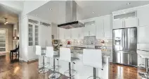  ??  ?? A penthouse condo on the ninth floor of one of the Domaine Mont-Laval buildings features a largely open floor plan, where the kitchen has such high-end finishes as acrylic cabinets, quartz countertop­s, a mosaic tile backsplash and engineered wood...