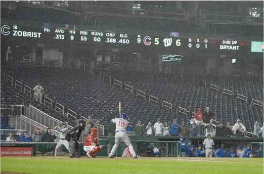  ?? NICK WASS/AP ?? Ben Zobrist bats as the rain falls during the ninth inning of Game 2 of the doublehead­er Saturday night in Washington. The Nationals swept the twinbill, which included over six hours of rain delays.