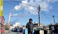  ?? (REUTERS) ?? A man walks near a coal-fired power plant in Harbin, Heilongjia­ng province, China
