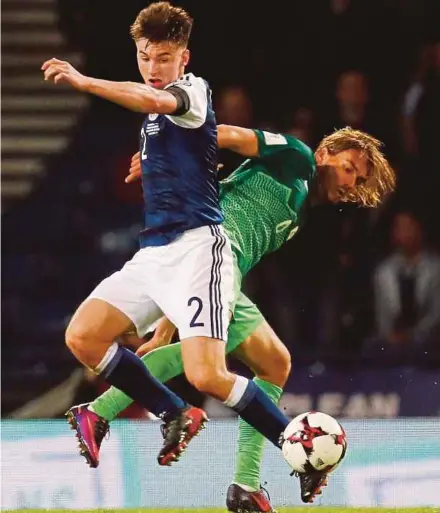  ??  ?? Scotland’s Kieran Tierney (left) is challenged by Slovenia’s Rene Krhin in their World Cup qualifier on Sunday.