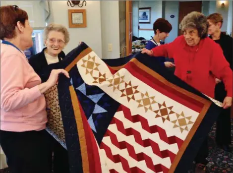  ?? BOB KEELER — MEDIANEWS GROUP ?? Peggy Bergman, left, Grace Bergman and Joanne Gressang hold the Quilt of Valor presented Jan. 25 to Grace Bergman. The 103-year-old, who served during World War II, is the oldest living female Marine in Pennsylvan­ia and the second oldest in the country.