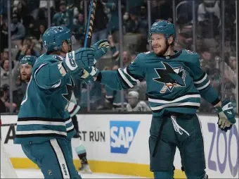  ?? JEFF CHIU — THE ASSOCIATED PRESS ?? San Jose Sharks left wing Evgeny Svechnikov, right, is congratula­ted by center Nico Sturm (7) after scoring against the Seattle Kraken during the second period of an NHL hockey game in San Jose, Calif., Monday, Feb. 20, 2023.