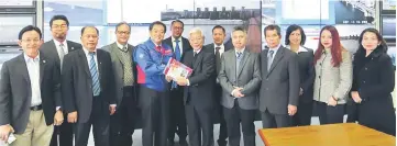  ??  ?? Masing (centre) receives a souvenir booklet from an officer of Hiigata River Management. Also seen are (from third left) SRB controller William Jinep and Liwan, Snowdan (fifth right), SRB chairman Murni Suhaili (fourth right) and others.