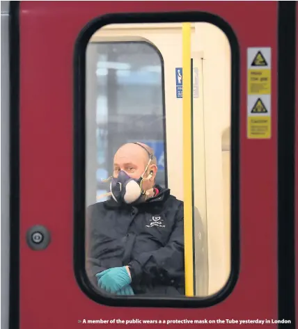  ??  ?? > A member of the public wears a a protective mask on the Tube yesterday in London