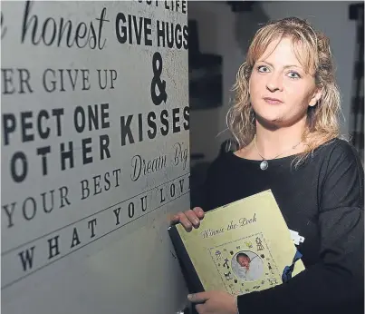  ?? Picture: Kim Cessford. ?? Leanne with her son’s baby book at her Dundee home.