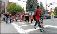  ?? TANIA BARRICKLO — DAILY FREEMAN FILE ?? Children and their parents cross the street in front of George Washington School in Midtown Kingston, N.Y.