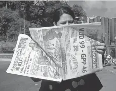  ?? MANAURE QUINTERO, EUROPEAN PRESSPHOTO AGENCY ?? A woman reads a daily newspaper in Caracas, Venezuela, that shows the number of legislator­s ( 99) the opposition obtained.