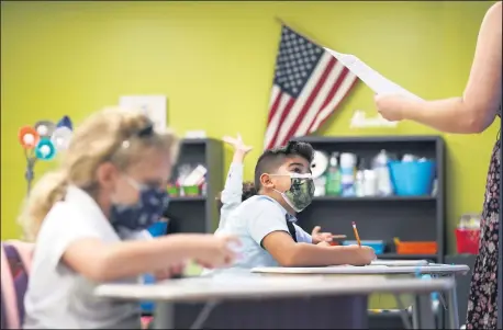  ?? LYNNE SLADKY — THE ASSOCIATED PRESS FILE ?? A student listens to the teacher’s instructio­ns at iPrep Academy on the first day of school in Miami on Aug. 23. Tumbling COVID-19case counts have some schools around the U.S. considerin­g relaxing their mask rules, but deaths nationally have been ticking up over the past few weeks,