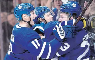  ?? FRANK GUNN THE CANADIAN PRESS FILE PHOTO ?? Toronto Maple Leafs defenceman Travis Dermott, right, is mobbed by teammates William Nylander and and Zach Hyman after scoring his first career goal Jan. 31.