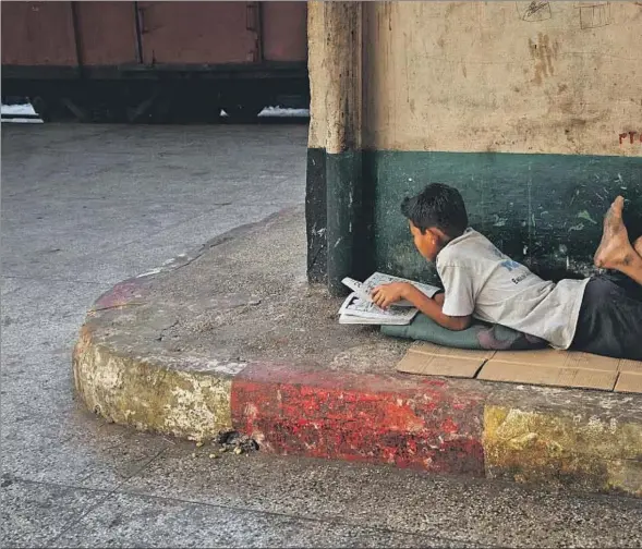  ??  ?? Niño leyendo en el suelo, una imagen tomada por el fotógrafo Steve McCurry en uno de sus viajes a Birmania