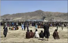  ?? SHEKIB RAHMANI — THE ASSOCIATED PRESS FILE ?? Hundreds of people gather near a U.S. Air Force C-17 transport plane at the perimeter of the internatio­nal airport in Kabul, Afghanista­n, on Aug. 16, 2021. The nearly 12 months since the chaotic end to the U.S. war in Afghanista­n haven’t been easy for Joe Biden. In the summer of 2021, the American electorate largely approved of the new president’s performanc­e.