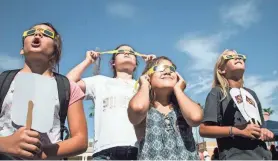  ?? NICK OZA/ARIZONA REPUBLIC ?? From left. Hailey Zehring, Madyson Zehring, Macie Zehring and Ashleigh Troth watch a 2017 solar eclipse in Arizona with their protective glasses.