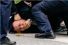  ?? Associated Press ?? Police pin down and arrest a demonstrat­or on Sunday in Shanghai. A day earlier, a crowd there protested COVID-19 rules and called on Chinese President Xi Jinping to step down.