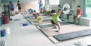  ??  ?? A trainee attempts the clean and jerk.