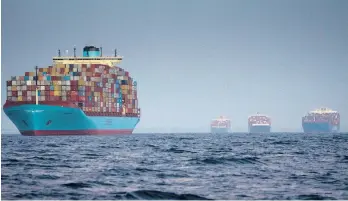  ?? ERIN SCHAFF/THE NEW YORK TIMES ?? Container ships wait to enter the Port of Los Angeles on Oct. 17. Surging inflation and supply chain disruption­s are disrupting global economic recovery.