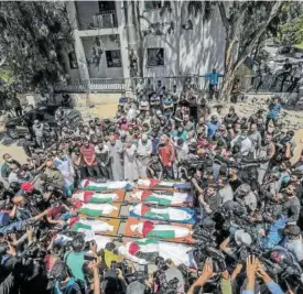  ??  ?? MASACRE EN UNA FAMILIA PALESTINA. Diez palestinos, miembros de una misma familia, murieron en la madrugada del sábado en un ataque aéreo israelí. Fuentes palestinas aseguraron que los diez miembros de la familia Abu Hatab son ocho niños y dos mujeres. Las fuentes describen el ataque como una “masacre” porque afirman que la casa de las víctimas fue bombardead­a sin previo aviso. En la foto, imagen del funeral por las víctimas.