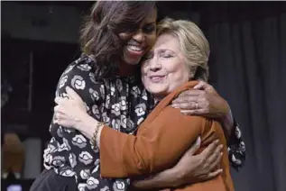  ?? —AFP ?? NORTH CAROLINA: US First Lady Michelle Obama embraces Democratic presidenti­al nominee Hillary Clinton during a campaign rally in Winston-Salem, North Carolina.