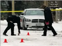  ?? WARD PERRIN / PNG ?? RCMP look for evidence Friday along Surrey’s 56th Avenue at 139th Street after two men were shot overnight.