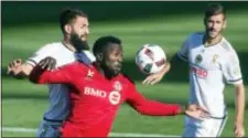  ?? CHRIS YOUNG — THE CANADIAN PRESS VIA AP ?? Toronto FC’s Jozy Altidore, center, shields the ball from the Union’s Richie Marquez, left, as Ken Tribbett looks on during the first half in Toronto on Saturday.