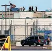  ?? [AP PHOTO] ?? People walk on the roof above the front gate of the Great Plains Correction­al Facility on Monday in Hinton.
