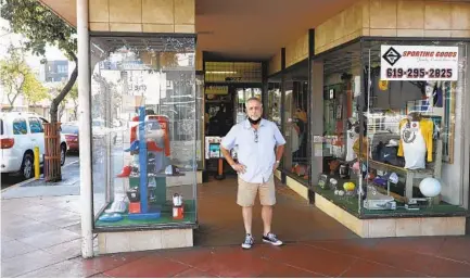  ?? JOHN GASTALDO ?? Gregg Schloss stands in front of the family business, an institutio­n in North Park. After 79 years in business, A&B Sporting Goods store in North Park is closing its doors on Dec. 31. Below, Joe Schloss and his father David Schloss in an undated photo.