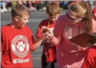  ??  ?? French Creek Elementary School teacher Tara Torres checks fourth grader, Hunter Young’s pedometer.